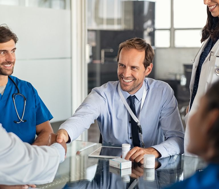 Businessman,Shaking,Hands,With,Doctor,In,Meeting,Room.,Doctor,And